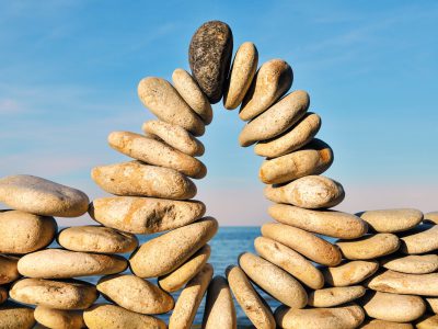 Arc of pebbles between of the stones on the seashore